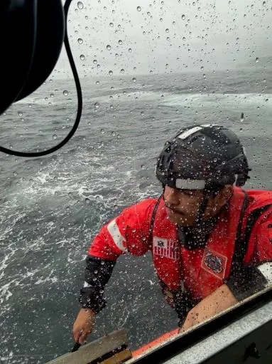 Parker Reef, Wash. — Petty Officer 3rd Class Mikko Smith, a crew member aboard Station Bellingham's 45-foot Response Boat–Medium, works to rescue the paddler. U.S. Coast Guard photo.