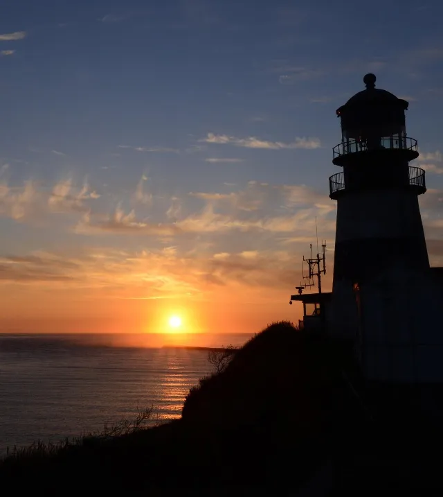 Ilwaco, Wash. — The sun sets over the Pacific as the Cape Disappointment Lighthouse stands vigil above the Columbia River Bar, Nov. 7, 2018. U.S. Coast Guard photo by Petty Officer 3rd Class Trevor Lilburn.